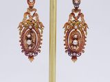 pair of gold and pearl earrings on a gold plated stand