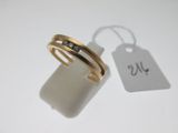 une bague en or sertie de deux diamants, à côté d'une étiquette de prix