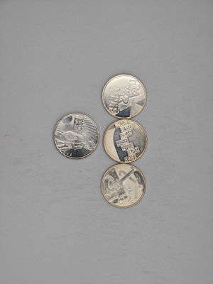 four different coins sitting on top of a table next to each other