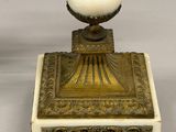 an antique brass and marble candelabra with a white marble base