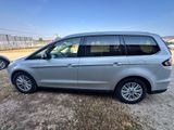 a silver minivan parked in a parking lot next to other cars