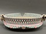 a white bowl with pink and green designs on it