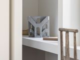 a small desk with a wooden chair in the corner of the room