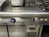 une grande cuisine en inox équipée de nombreux appareils électroménagers