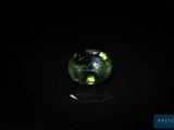 une tourmaline verte posée sur un fond noir