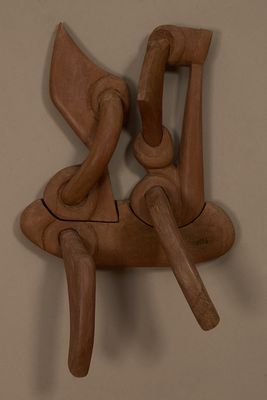 une sculpture en bois représentant un homme et une femme assis sur une chaise