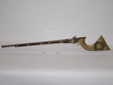 an old gun with a wooden handle on a white surface