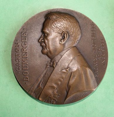 a bronze medal with a picture of a man on it