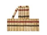 several old books stacked on top of each other on a white surface