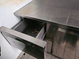 an open drawer in the middle of a stainless steel counter