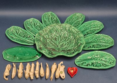 une assiette verte sur laquelle se trouve un chou, à côté d'autres assiettes et cuillères