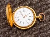 une montre de poche en or avec des chiffres romains