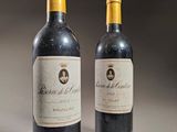 two bottles of wine sitting on top of a table next to each other