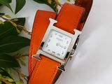 an orange leather watch band with a white square face