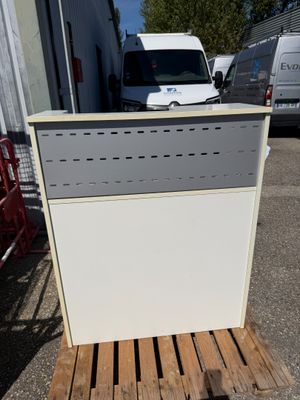 an image of a white and grey refrigerator sitting on a pallet