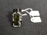 an image of a green tourmaline and diamond ring on a black surface
