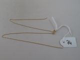 three gold necklaces with a price tag on a white background