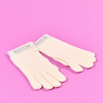 une paire de gants blancs sur fond rose