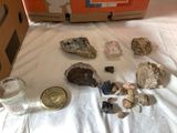 a box of rocks and a glass of water on a bed