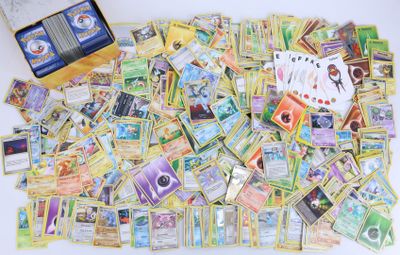 une pile de cartes Pokémon et une boîte de cartes