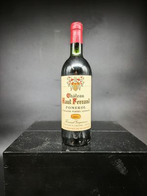 une vieille bouteille de vin rouge posée sur une boîte noire