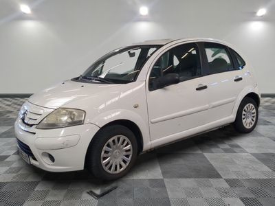 la photo d'une petite voiture blanche garée sur un sol en damier