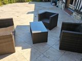 four wicker chairs and a table on the patio