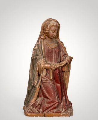 une statue en bois représentant une femme tenant un livre
