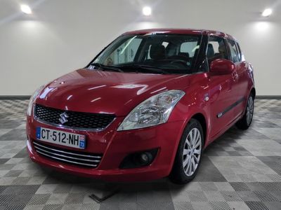 la petite voiture rouge est garée dans une grande pièce