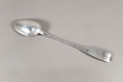 une cuillère en argent avec un manche de cuillère sur une table