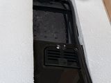 a black cell phone sitting in a box on a table