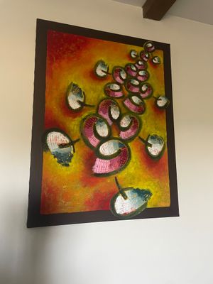 une photo d'un tableau accroché au mur au-dessus d'un lit