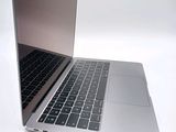 a silver laptop with a black keyboard on a white surface
