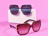 une paire de lunettes de soleil posée sur une boîte, sur une surface rose