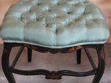 a chair with a tufted seat on it in a room