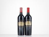 two bottles of red wine sitting on top of a table