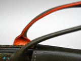 a close up of a handbag with a red handle