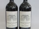 two bottles of red wine sitting next to each other on a table