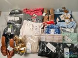 une boîte contenant des vêtements et des chaussures, posée par terre