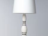 une lampe de table blanche avec un pied noir et un abat-jour blanc