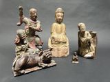 several asian figurines are displayed on a gray surface
