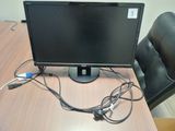 a computer monitor sitting on top of a wooden desk