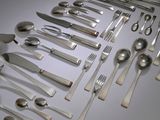 a lot of silver spoons and spoons on the table