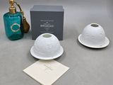 two white dishes and a blue bottle on a table