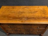 an old wooden chest of drawers on a carpeted floor