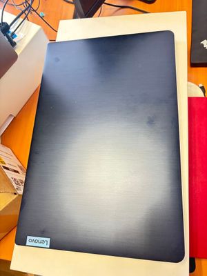 un ordinateur portable posé sur une table, avec une boîte dessus