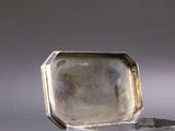 a silver box that has a ring inside of it