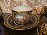 a cup and saucer with a picture on it on a table