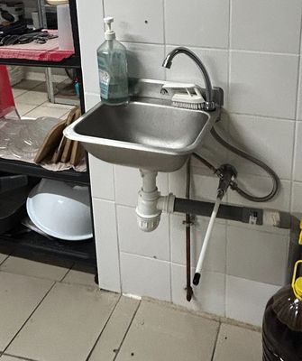 a kitchen with a sink and a shelf with dishes on it