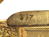 a close up of a gold plated object with a bird on it